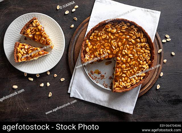 Homemade caramel-peanut cheesecake on a dark background. Morning delicious bakery cake