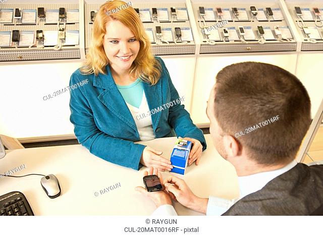 Employee showing a mobile to a customer