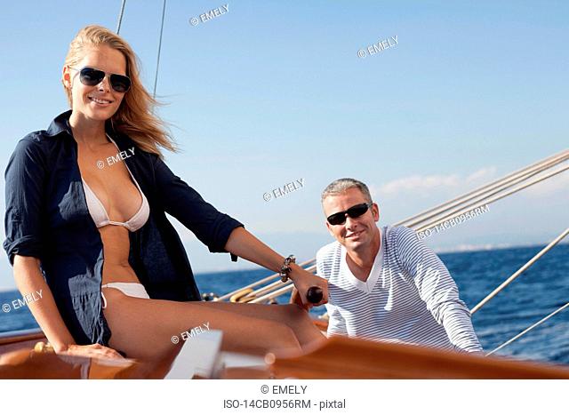 woman and man smiling steering boat