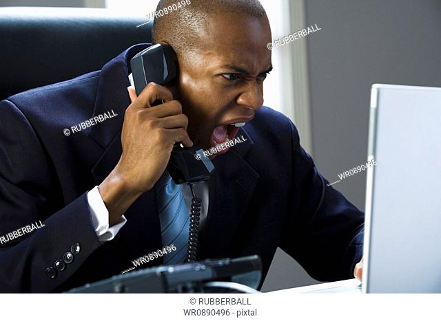 Close-up of a businessman shouting on the phone