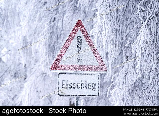 29 November 2023, Hesse, Glashütten: An icy sign on the Feldberg in the Taunus warns of falling ice...Today, light snowfall will continue at times from the...