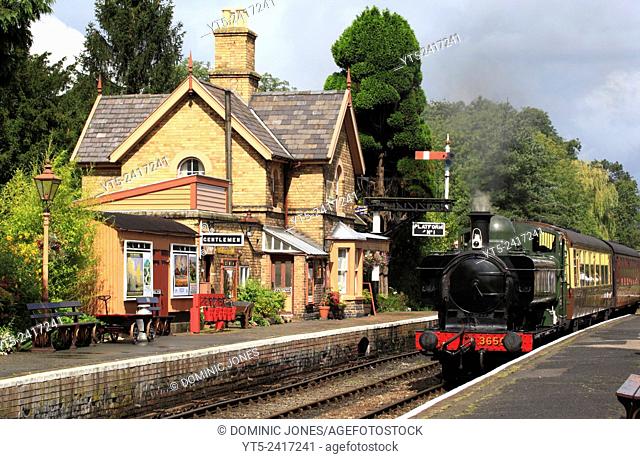 A GWR Pannier-tank 0-6-0 locomotive, no. 3650 draws a short passenger train into a summery Hampton Loade station, re-creating a scene which would be reminiscent...
