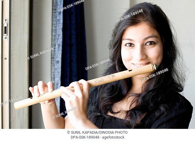 A portrait of maharashtrian girl playing a flute Pune Maharashtra India Asia MR # 686EE