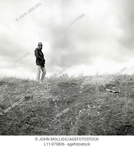 Woman in field on cloudy day