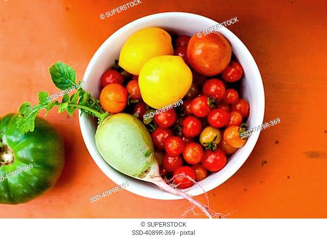 Bowl of fresh picked fruit and vegetables, studio shot