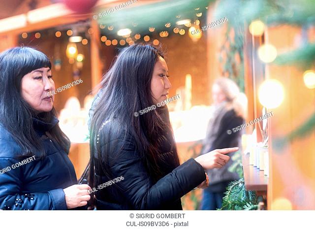 Mother and daughter window shopping at Christmas market, Freiburg, Baden-Wurttemberg, Germany