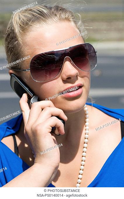 Blond woman with a cell phone talking outdoor