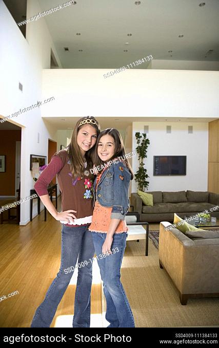 Sisters standing together in living room