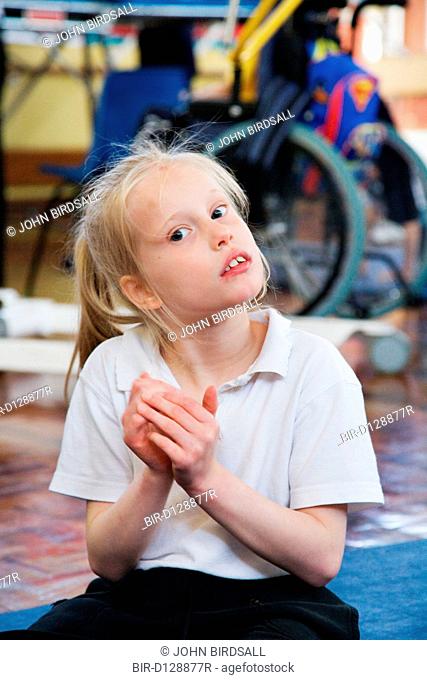 Girl with physical and learning difficulties clapping her hands