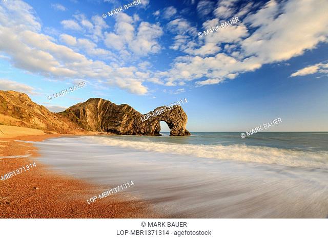 England, Dorset, Lulworth. The natural Rock Arch of Durdle Door lit by the evening sun
