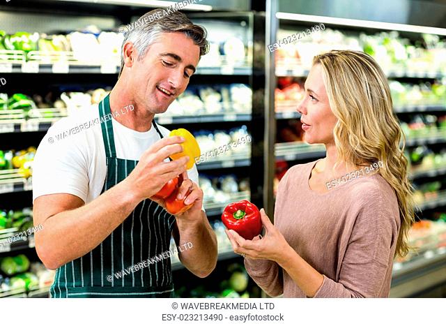 Smiling blonde woman buying a vegetables at supermarket