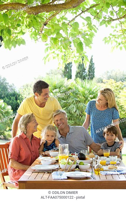 Multi-generation family having breakfast outdoors