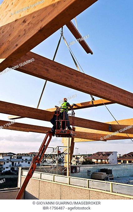 Workman building a structural glulam frame on a cherry picker
