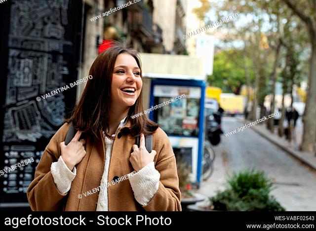 Happy young woman in the city looking around, Barcelona, Spain