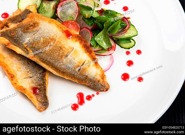 Fillet of zander with vegetables on a plate in a restaurant