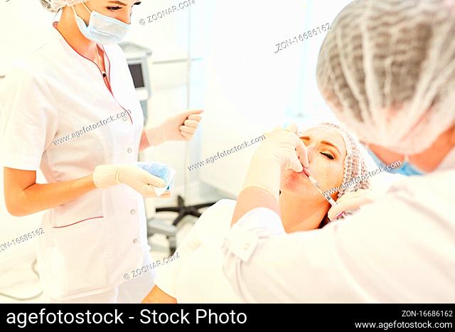 Ärzteteam in der Schönheitsklinik beim Lippen aufspritzen mit Hyaluronsäure als Hautfüller