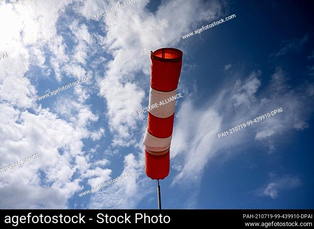 19 July 2021, Mecklenburg-Western Pomerania, Altefähr: A windsock stands almost horizontally in the air and thus indicates quite strong wind