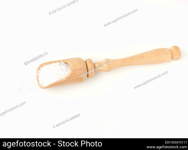 large crystals of white sea salt in a brown wooden spoon, top view