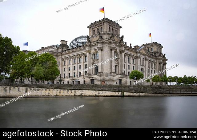 05 June 2020, Berlin: The flags on the Reichstag building are waving in the wind. (shot with long exposure) Photo: Paul Zinken/dpa-Zentralbild/dpa