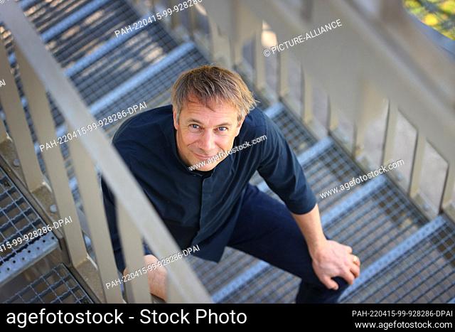 14 April 2022, Bavaria, Munich: Jo Lendle, writer and publisher of Carl Hanser Verlag, sits on a staircase in front of the publishing building