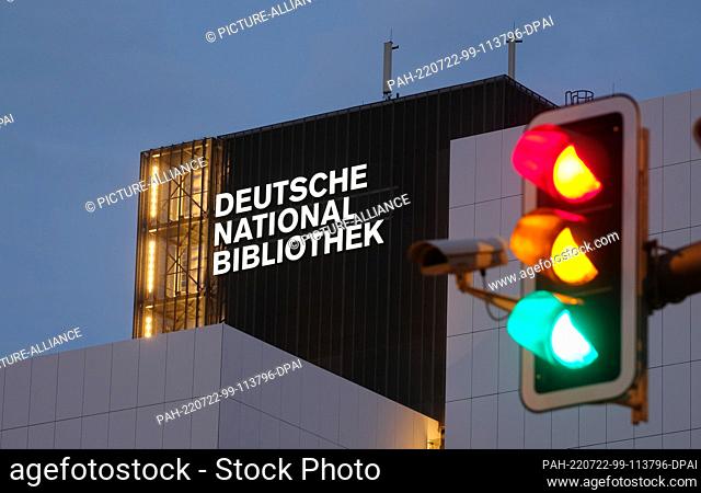 21 July 2022, Saxony, Leipzig: The new lettering ""Deutsche Nationalbibliothek"" (DNB) shines on a 55 meter high building of the former German Library with a...