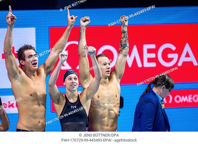 American swimmer Caeleb Dressel (R) celebrates winning in his third gold medal of the evening with American teammates Mallory Comerford and Nathan Adrian (L)...