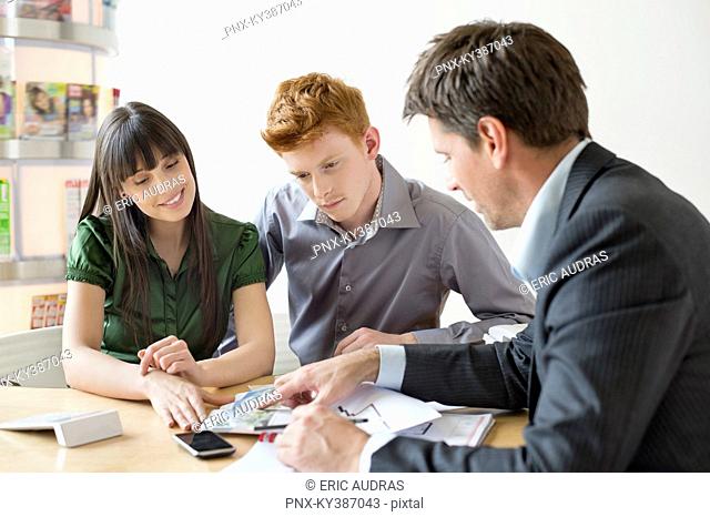 Real estate agent discussing property documents to his clients
