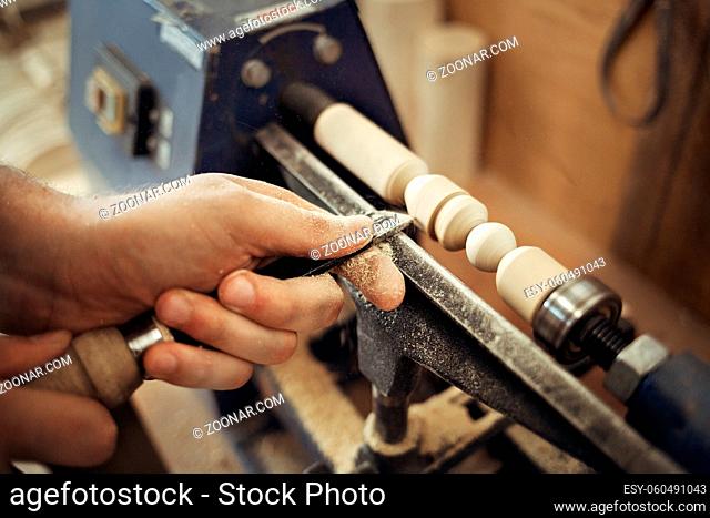 Work at the lathe. Master's hands with a chisel close-up. Processing of a wooden part. Employment and labor. Workplace of a carpenter and Turner