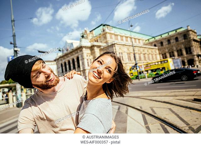 Austria, Vienna, happy young couple dancing Viennese waltz in front of state opera