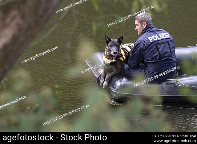 20 July 2023, Hesse, Villmar: Using a cadaver-sniffing dog, police officers search for the body of a woman on the Lahn River from a boat