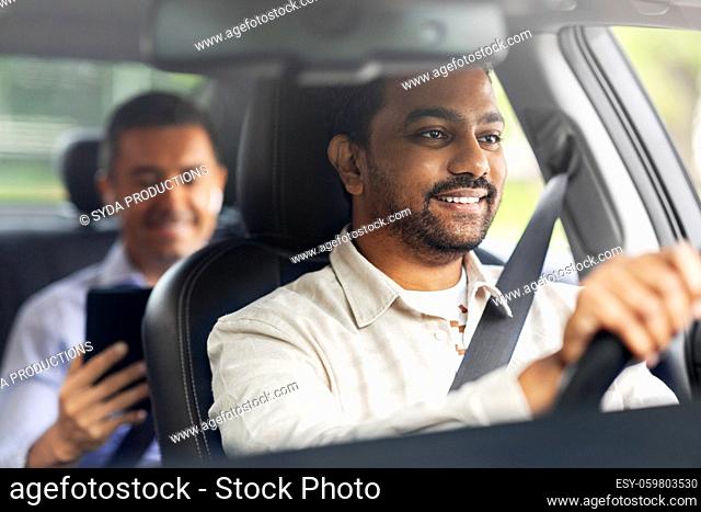 indian male driver driving car with passenger