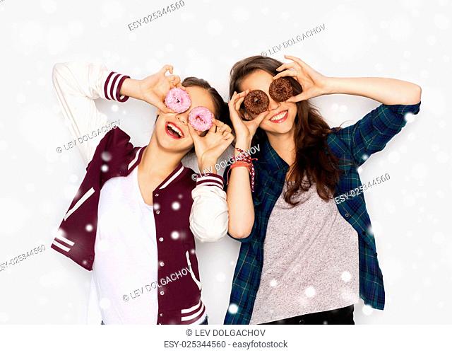 winter, christmas, people, holidays and fast food concept - happy smiling pretty teenage girls or friends with donuts making faces and having fun over gray...