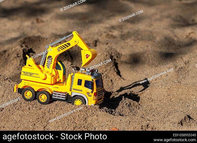 Toy excavator in the sand. Children's toy