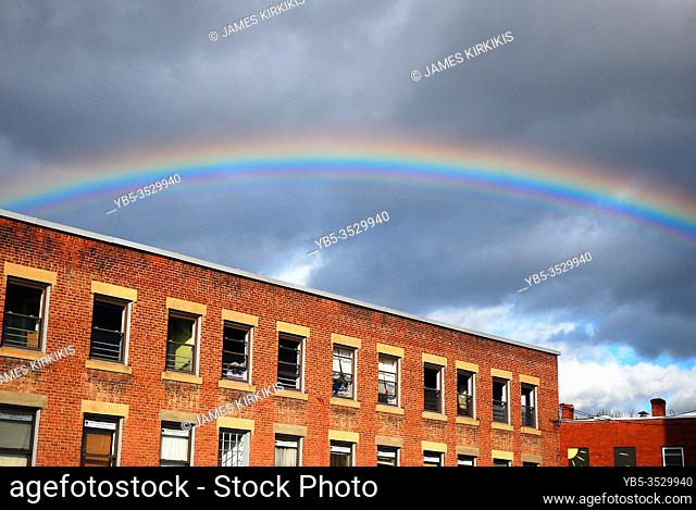 A rainbow appears over an old, repurposed industrial building in Keene, New Hampshire