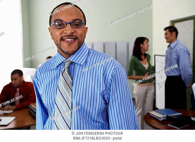Young businessman with coworkers in background