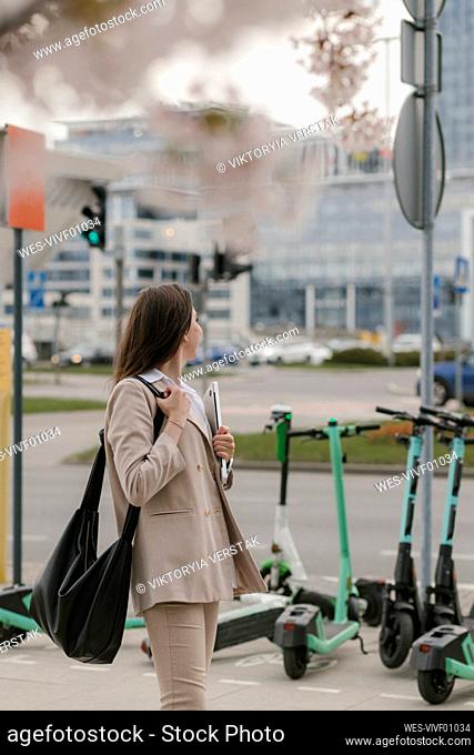 Young businesswoman standing at footpath