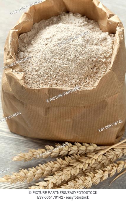 Dried wheat and wheat flour in a paper bag