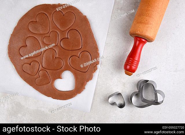 Valentines Day Baking: Top view of chocolate cookie dough with hearts shapes and rolling pin