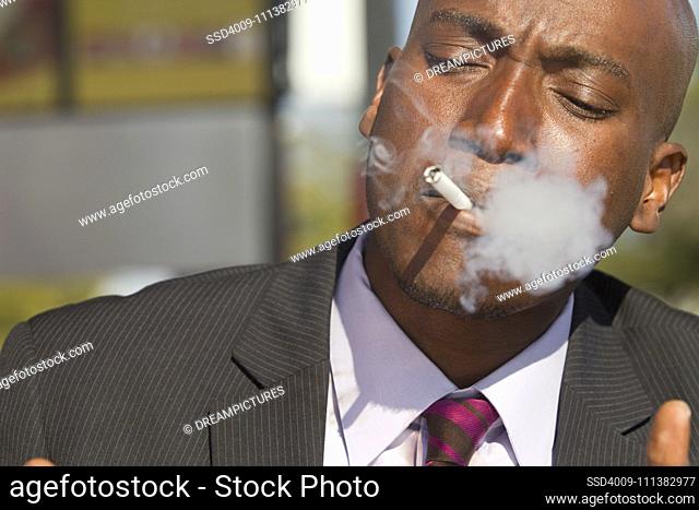 African American businessman smoking cigarette