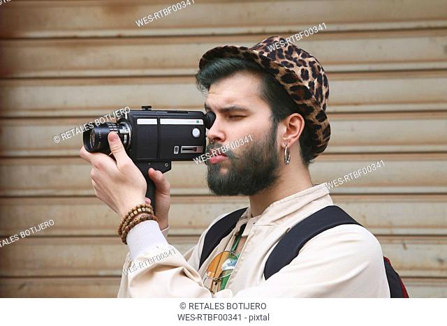 Young man using a vintage video camera