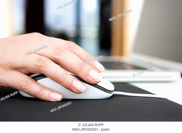 Germany, Bavaria, Diessen am Ammersee, Close up of woman's hand on mouse with mousepad
