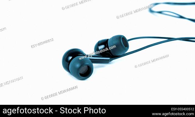 earphones closeup over the white surface.blue tone