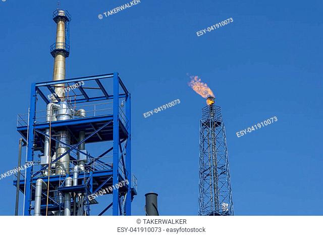 Gas flares in petroleum refinery with blue sky background