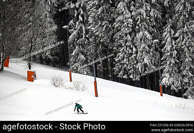 06 December 2023, Saxony, Oberwiesenthal: A snowboarder descends the slope on the Fichtelberg. Saxony's largest alpine ski area started the season on the same...