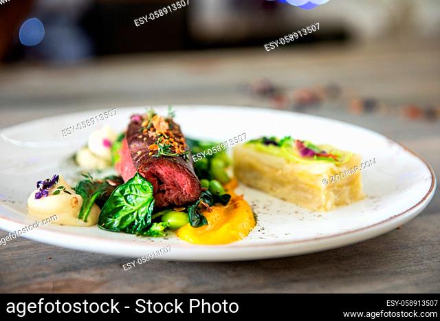 Beef meat with green peas, sweet potato mousse, roasted spinach and zucchini gratin