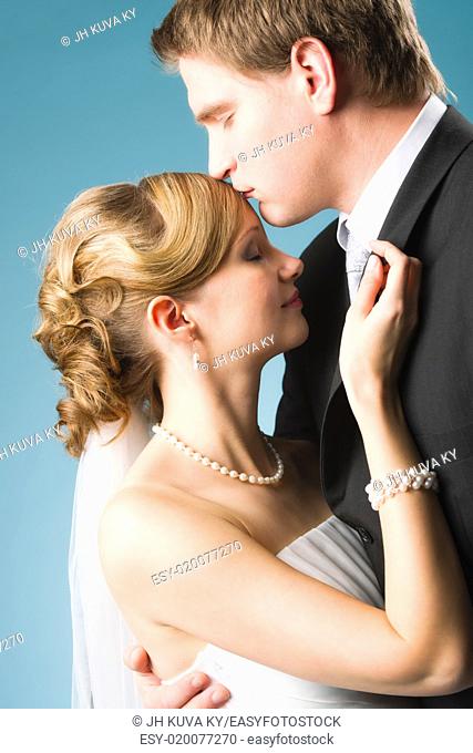Happy beautiful couple, groom kissing bride forehead