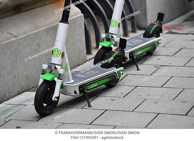 LimeBike, Lime Bike US e-scooter rental company. E-scooters, electric scooters stand on a sidewalk in downtown Munich. Leihroller, Mietroller, Mietscooter