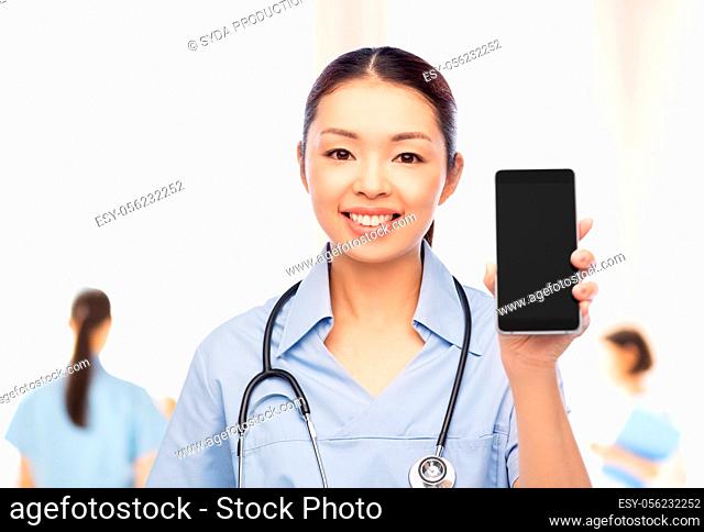 asian female nurse with smartphone at hospital