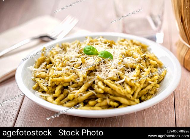 Pasta with pesto sauce and parmesan on a plate
