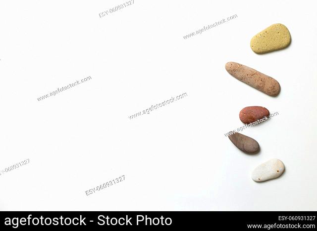 Natural pebble stones on white background. top view, copy space